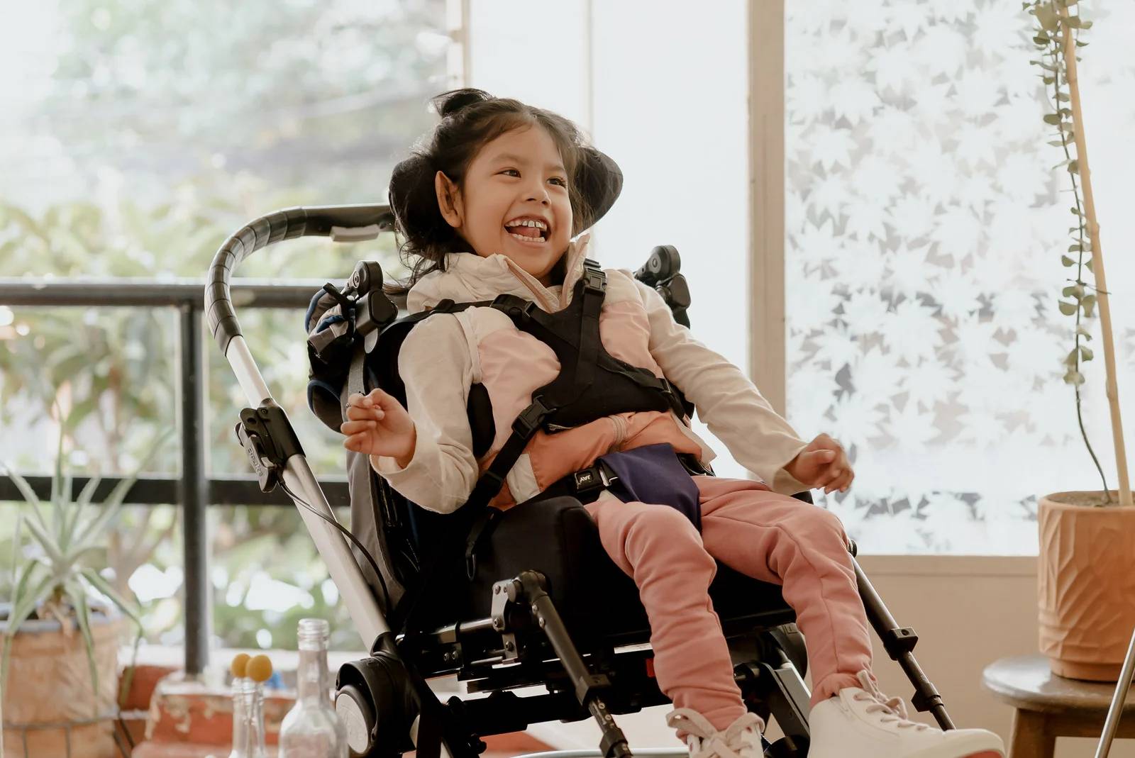 Child in Wheelchair Smiling at Home Showing Special Needs Transit Support