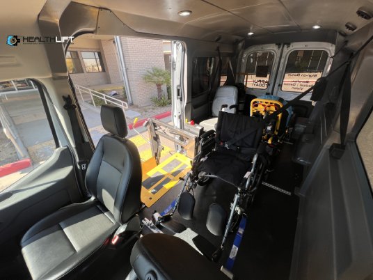 Interior of a HealthLift Accessible Van Featuring a Secured Wheelchair and a Medical Stretcher