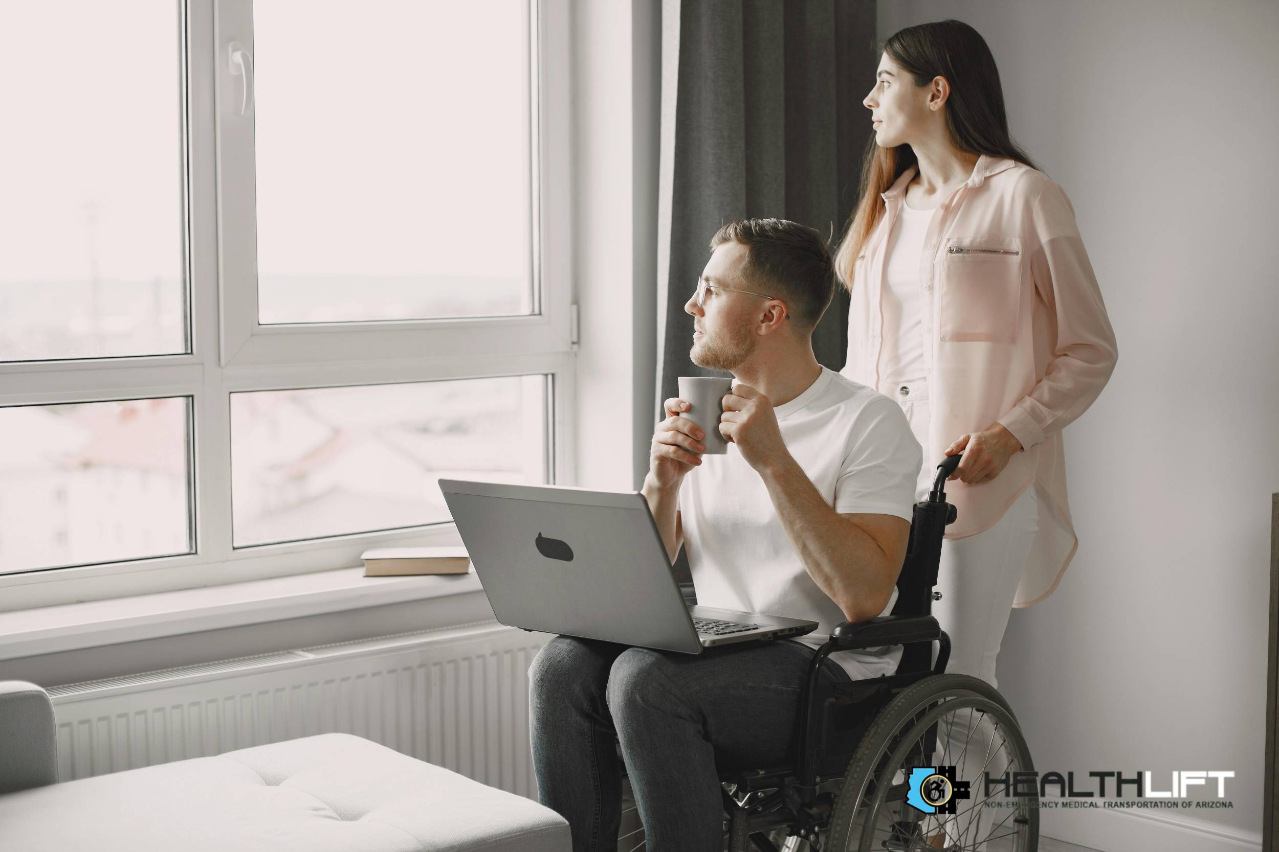 Man in Wheelchair Looking Out Window with Caregiver